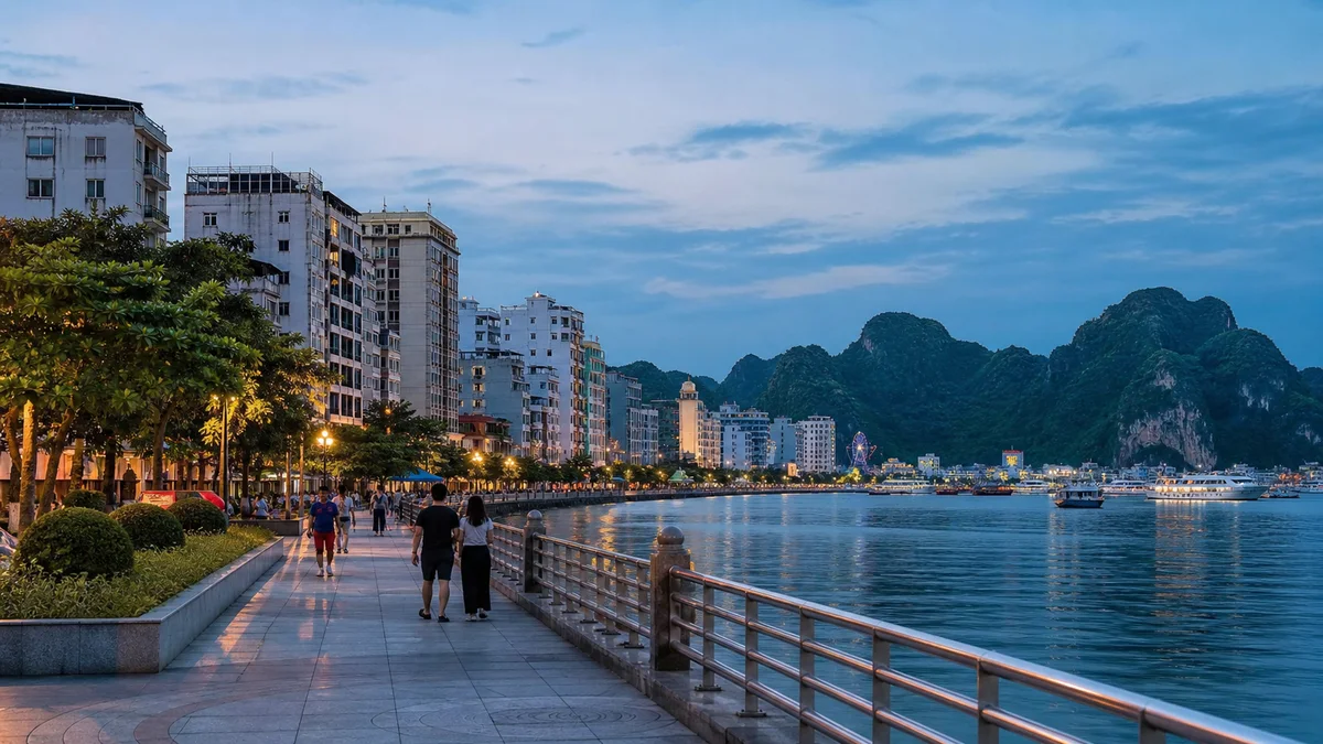 People walking beside an urban bay at blue hour with limestone hills beyond